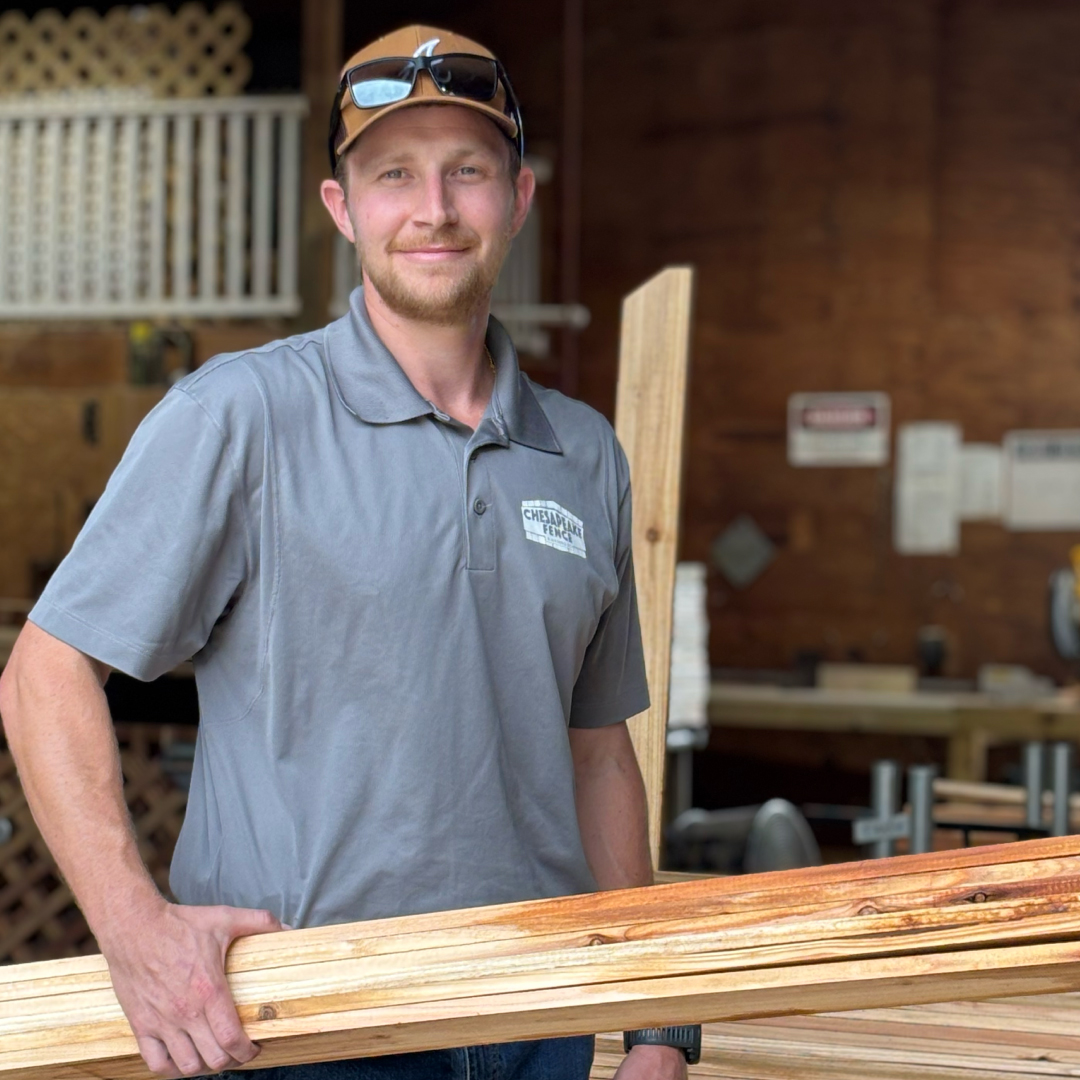 Chesapeake Fence team member holding finished wood fencing